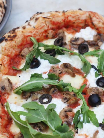My dreamy, airy dough is the star of this pizza, topped with creamy cheese, mushrooms, black olives, and fresh arugula. It's a vegetarian option that is packed with flavor.