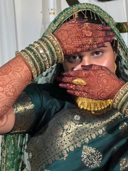 The bride showing off her stunning henna stain with her beautiful green saree and bangles. This is the complete bridal look.