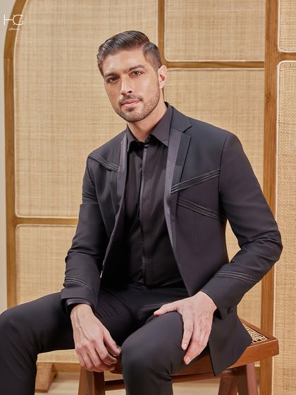 A seated portrait in the precision suit, highlighting its impeccable tailoring and how it maintains its structure and sharp lines.