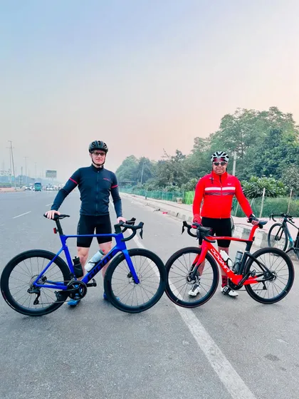 Two riders proudly displaying their blue Giant and red Pinarello bikes.