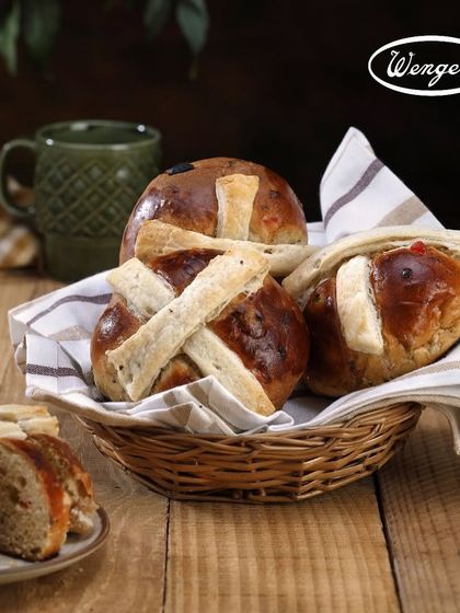 A basket of our freshly baked Hot Cross Buns, ready to be enjoyed. The aroma of spices and sweet bread fills our bakery every Easter season.
