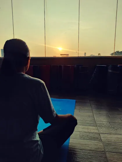 Here, a student practices Tratak naturally with the rising sun. Gazing at the early morning sun is a traditional method that helps improve vision and brings a sense of calm and focus.