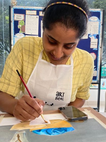 This student is wearing an Art Beat apron, ready to dive into her painting session. We provide everything you need.