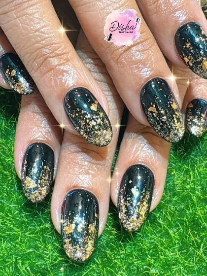 A bold and edgy look with black nails and a shower of gold glitter.