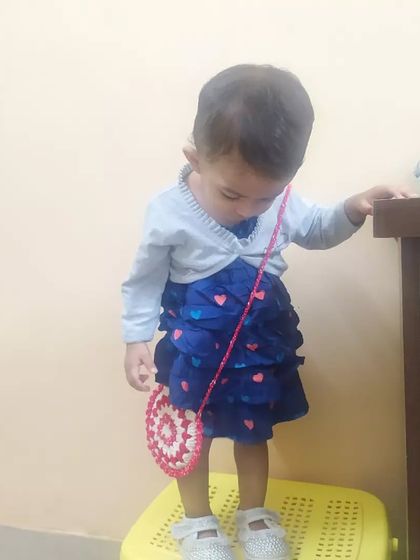 A candid moment of my daughter with her little crochet sling bag. It’s lightweight and easy for her to wear.