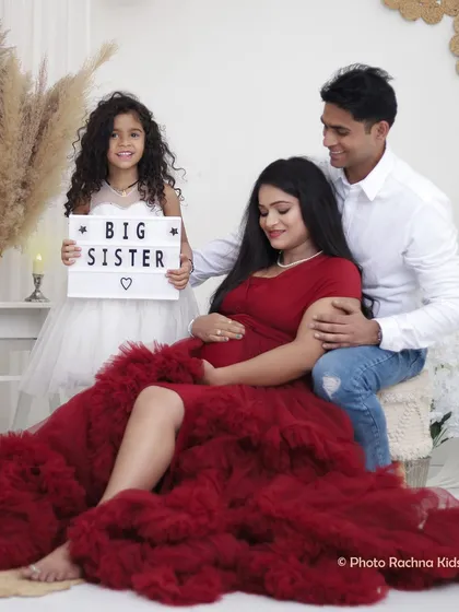 Welcoming a new baby is a family affair. We love including older siblings, and this shot with a "Big Sister" announcement sign is a perfect way to capture the excitement of the growing family.