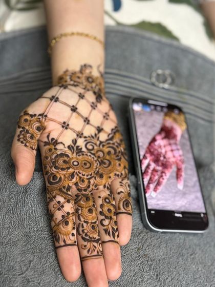 A stylish net or 'jaal' pattern on the back of the hand, combined with a floral cuff. This is a popular modern fusion look.