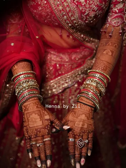 The beauty of a mature henna stain against a rich red bridal lehenga. The color is deep, dark, and absolutely perfect for the big day.