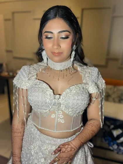 The full effect of this modern cocktail look. The structured, embellished top is complemented by equally glamorous makeup, featuring a silver-toned smokey eye and flawless skin.