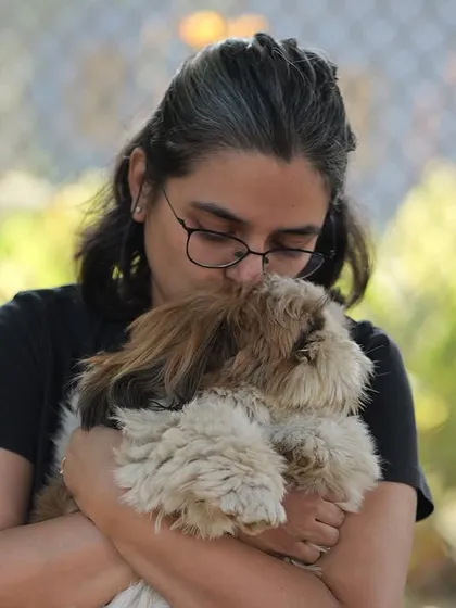 A close-up of a guest giving her fluffy Shih Tzu a kiss during our dog party. These events are all about celebrating the love between pets and their parents.