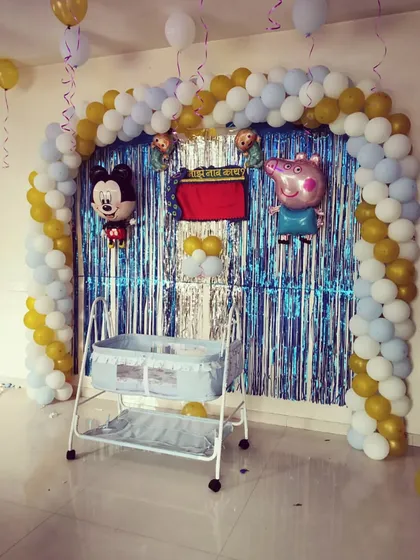 A wide shot of the naming ceremony decoration, showing the full balloon arch and cradle area.