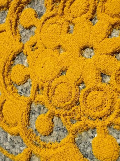 A close-up of a yellow Rangoli pattern. This color is often made from turmeric, a great example of how we can find art materials right in our own kitchens.
