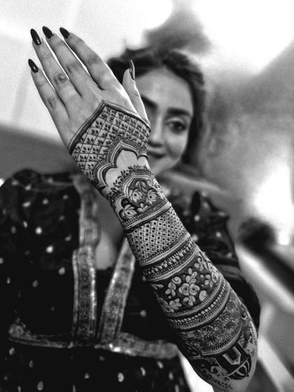 A beautiful black and white portrait of a bride, her intricate mehendi design adding to her elegance.