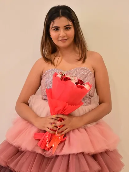A sweet pose with a bouquet, the makeup looks soft and pretty, complementing the pink tones of the dress.