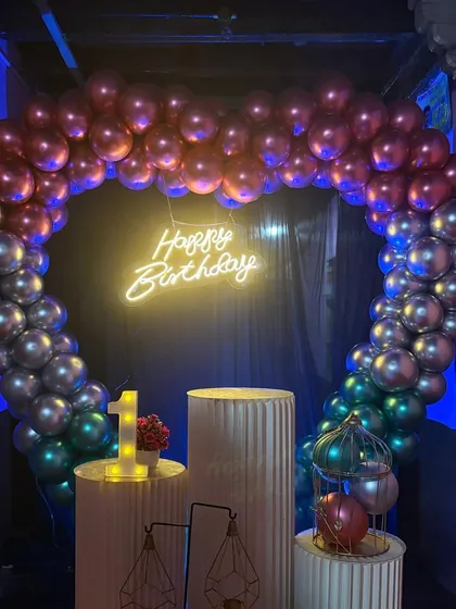 Another angle of the heart-shaped balloon arch for a first birthday. The chrome balloons catch the light beautifully, and the neon sign adds a modern touch.