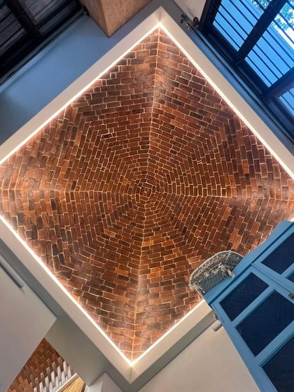 The ceiling of the Harlur Jagali house features a stunning cloister dome made of brick. The concentric squares of brickwork are highlighted by perimeter lighting, turning the ceiling into a dramatic focal point.
