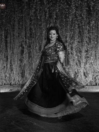 A dynamic solo portrait in black and white, capturing the movement of the lehenga. This adds a sense of energy and celebration to the wedding album.