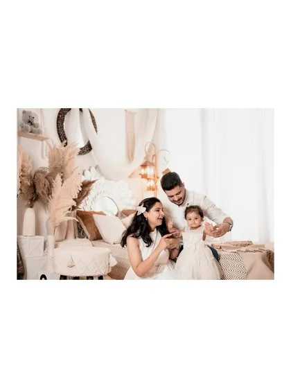 A beautiful family moment in a boho-chic studio setup. The warm lighting and intricate details of the decor create a cozy and inviting atmosphere.