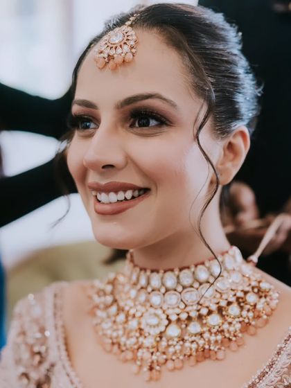 A close-up of the bride's happy face. Her natural smile is the highlight, complemented by a soft and radiant makeup look.
