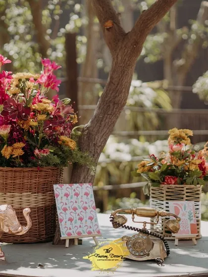 A charming corner with vintage and traditional props. An old-fashioned telephone, brass elephant figurines, and baskets of fresh flowers create a beautifully styled vignette.