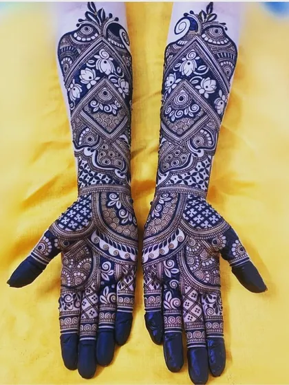 This is a perfect example of our intricate traditional work. The design uses negative space with bold lines to create a stunning contrast, featuring detailed floral and geometric patterns for a classic bridal look.