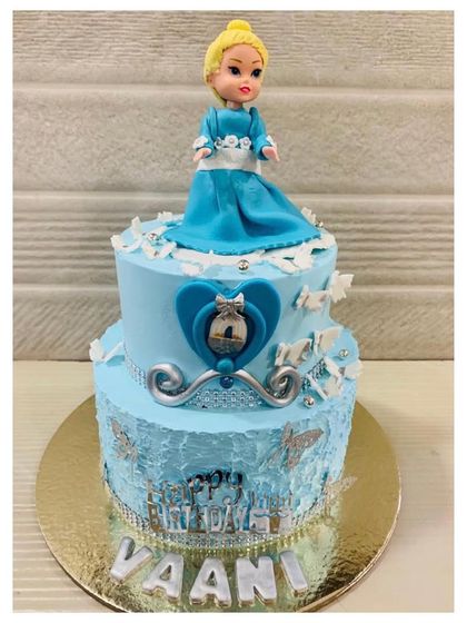 A beautiful two-tiered princess doll cake. The design features a lovely blue dress and intricate details, making it a dream cake for a little princess.