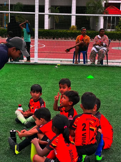 A coach sits down with the U7 team for a post-game chat, a crucial time for learning and reflection.