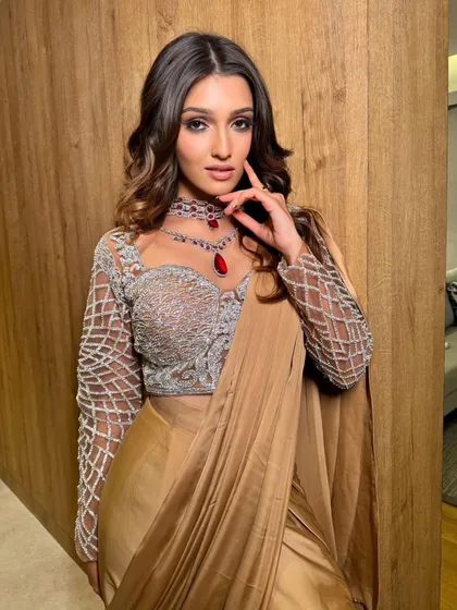 Golden hour in a golden satin saree. This look exudes glamour, and the drape is styled to catch the light beautifully.