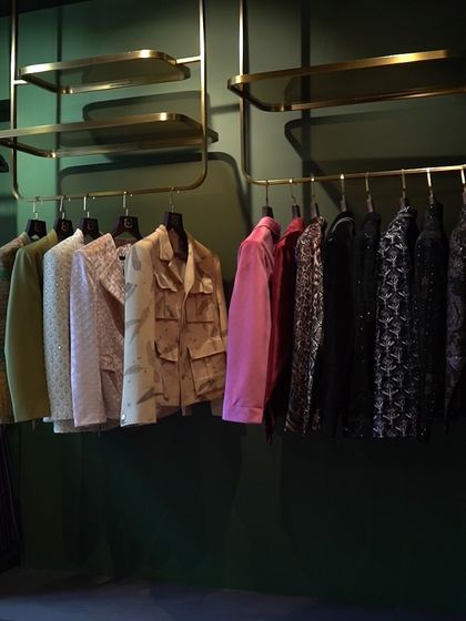 A wide shot of our clothing racks, showcasing the variety of styles we offer. The studio's layout allows for easy browsing and a comprehensive view of our work.
