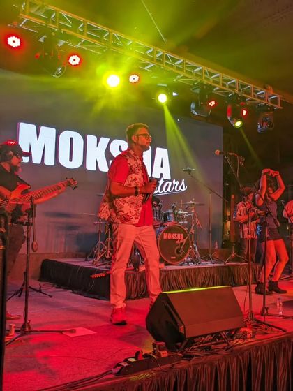 The band performing under red and yellow lights at the Karnataka Golf Association. This photo shows our ability to adapt our performance to different venues and ambiances.