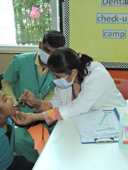 A dentist conducts a check-up during our on-campus dental camp. We prioritize our students' health and regularly organize wellness events to ensure their well-being.