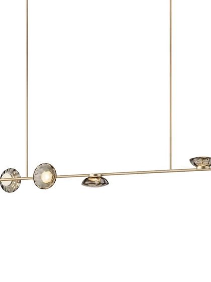 A linear Ceto configuration with a champagne finish, its elegant form perfect for suspending over a long table or island.