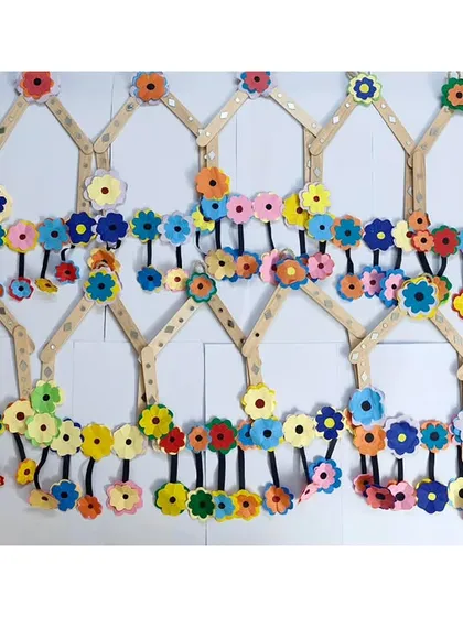 A beautiful wall hanging made by our students during summer camp. This project involved working with ice cream sticks and foam flowers to create a lovely piece of decor.