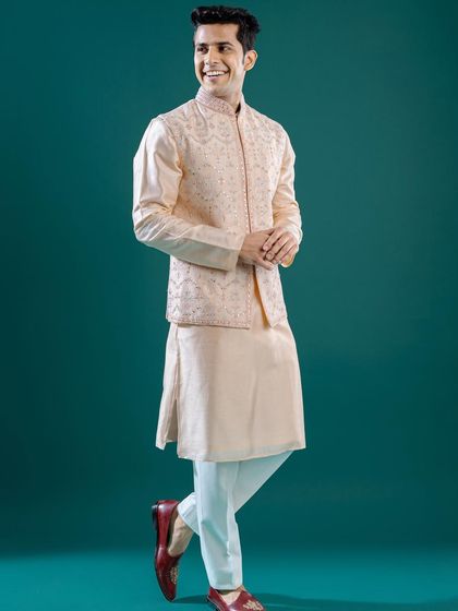 A full-length view of a peach-colored Jawahar jacket with delicate mirror work. This ensemble, full of grace and grandeur, is a perfect choice for any celebration.