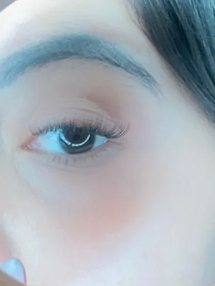 A close up look through a magnifying mirror at a light cat eye wing. This style adds a subtle flick to the outer corner for a flirty, defined look.