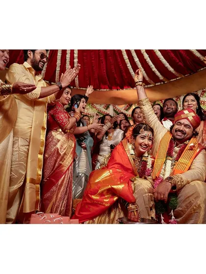 A moment of pure celebration and victory as the couple completes their wedding rituals, surrounded by cheering family and friends.