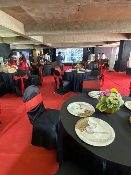 Our expertise extends beyond weddings to professional corporate events. This setup for a real estate sales exhibition features a bold red and black color scheme, organized seating, and branded displays to create a polished and impactful environment for business.