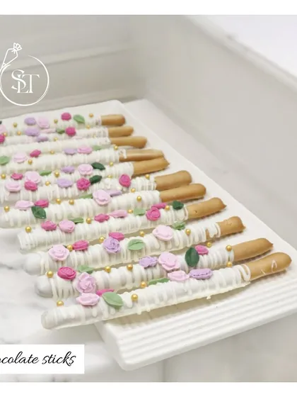 These elegant chocolate sticks are a perfect example of our detailed craftsmanship. Each stick is dipped in smooth white chocolate and delicately decorated with tiny, handcrafted sugar flowers and leaves, making them as beautiful as they are delicious.