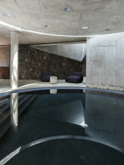 Another view of the Hamam at K-Lagoon, showing the interplay of raw concrete, local stone, and water. The space is designed to be a sensory experience.