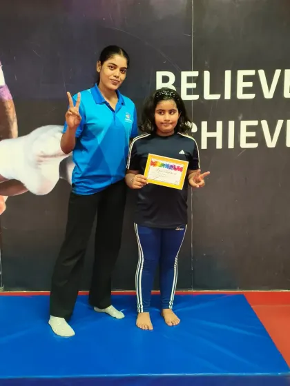 This student looks proud as she receives her certificate, marking her progress.