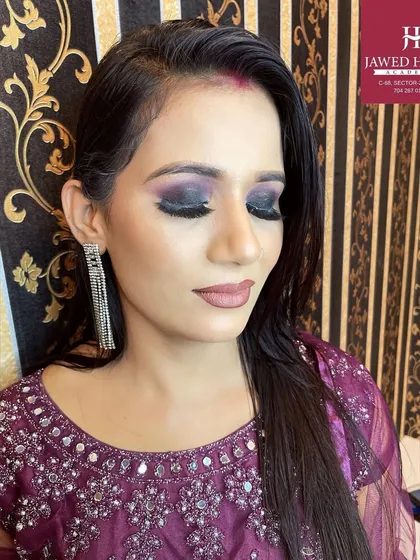 A demonstration of a classic smokey eye with a hint of purple, paired with a nude lip for a balanced, glamorous look.