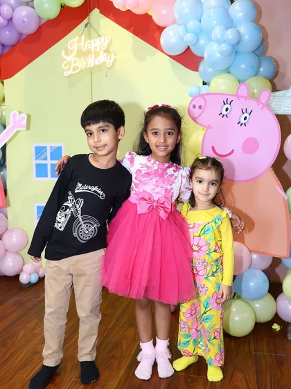 The birthday girl and her friends pose in front of the Peppa Pig house backdrop. It's a wonderful memento of a fun day with friends.