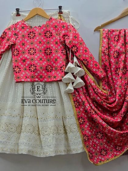 Another angle of the pink and white mother-daughter lehenga set. The combination of the embroidered skirt and the vibrant printed blouse and dupatta makes it a standout choice for festive events.
