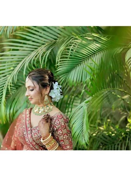 A profile view that highlights the elegant hairstyle and the way the makeup complements the bride's features and jewelry.