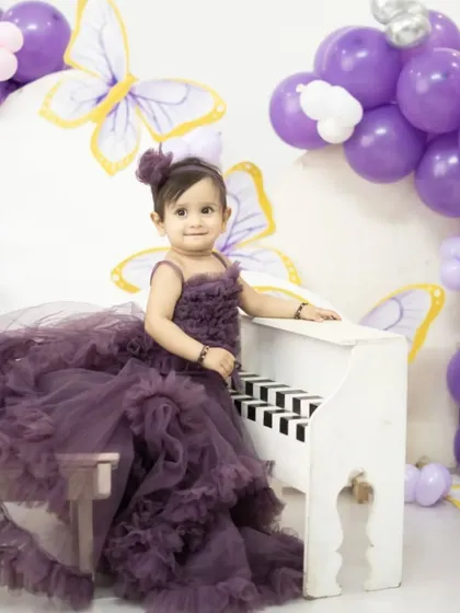 Planning a pre-birthday shoot for your little one? This grand purple ruffle gown will make your little angel feel like a fairytale princess. Available to rent or buy.