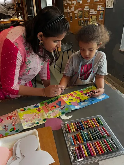 An instructor offers one on one support, helping a young camper with her colorful crayon illustrations for her storybook. We ensure every child gets the attention they need to bring their vision to life.