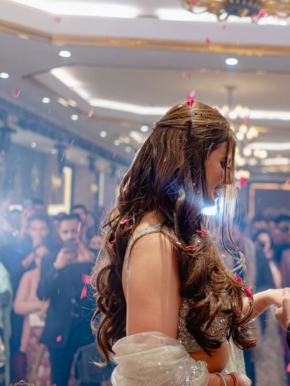A beautiful candid of the bride during her ring ceremony, with rose petals showering down, creating a magical, dream-like effect.