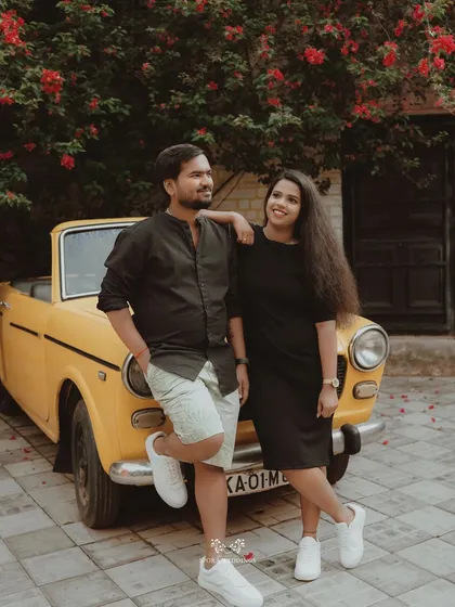 A stylish shot of the couple leaning against a vintage car, looking happy and in love.