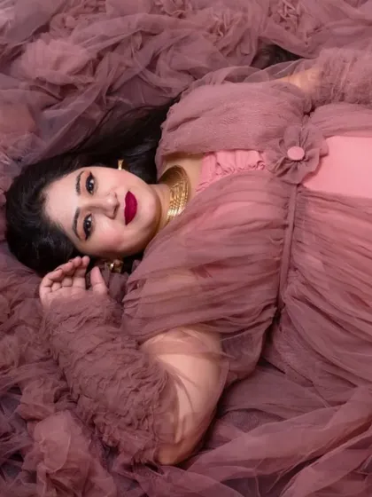 A creative top down shot, with the mom to be enveloped in the soft fabric of her tulle gown. This artistic angle provides a unique and beautiful perspective.