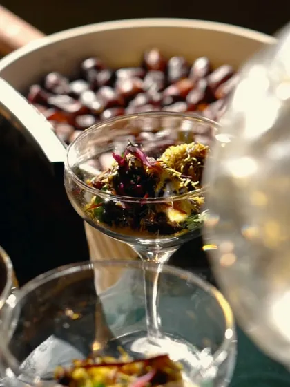 A beautifully presented Khajur Ki Chaat in a coupe glass. This innovative dish balances the sweetness of dates with the tang of chaat spices.